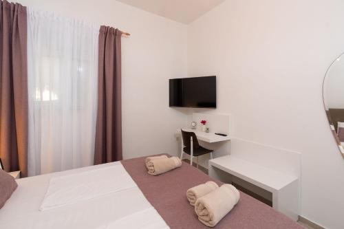 a bedroom with a bed and a desk and a television at Luxury apartments Lun in Lun