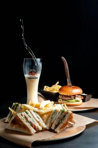 a plate with a sandwich and french fries and a drink at Pharae Palace in Kalamata
