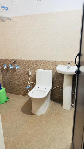 un baño con inodoro y lavabo en SGH Mysore dorm bus rail station, en Mysore