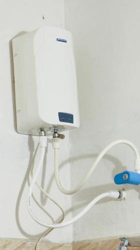 Una pared blanca con un tanque blanco en una pared en SGH Mysore dorm bus rail station, en Mysore