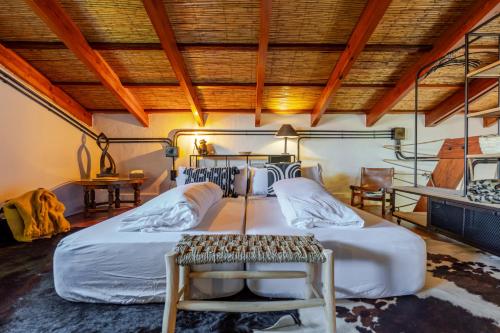 a bedroom with two beds and a wooden ceiling at Karibu Lodge Boutique in Vega de San Mateo