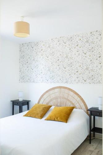 a bedroom with a white bed and two tables at La Casinière Coëtquidan in Guer