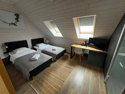 a bedroom with two beds and a desk and a computer at Hiiumaa Sõru Puhkemaja in Sõru