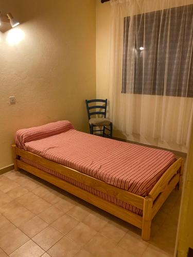 a bedroom with a bed with a chair and a window at gîtes de corse in Ventiseri