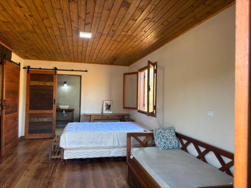 a bedroom with a bed and a wooden ceiling at Morada Canto do Sol in São Bento do Sapucaí