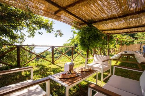 a patio with a table and chairs and a pergola at Casa Rosaria Amalfi Coast in Vietri sul Mare