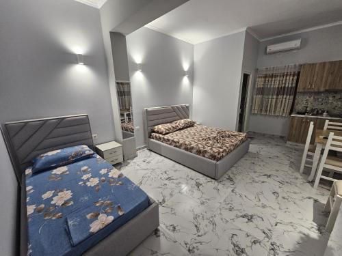 a bedroom with two beds and a room with tables at Mesaiz in Vlorë