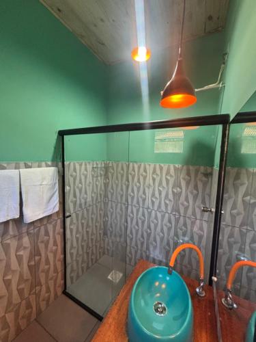 a bathroom with a blue sink and a shower at Casa natureza in Paraty
