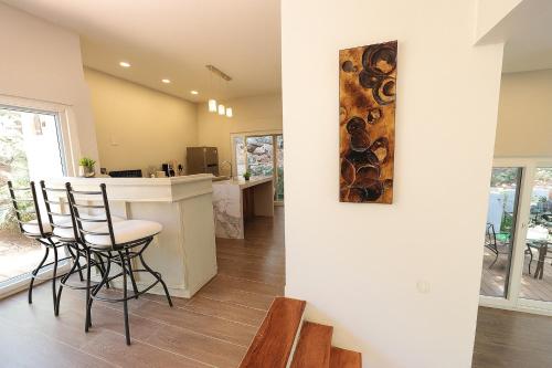 eine Küche und ein Wohnzimmer mit einer Bar und Stühlen in der Unterkunft Casa Luminiere- Keyhole Bay #5 home in Roatán