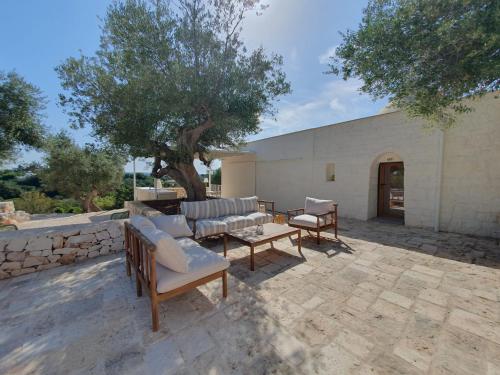 a patio with chairs and a table and a building at Trullo Antonelli in Antonelli