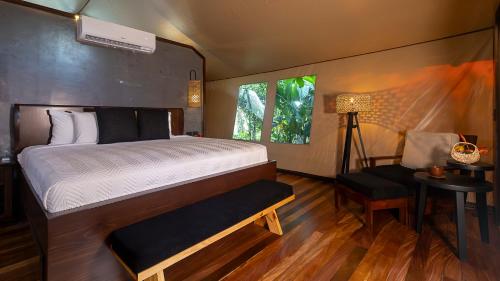 a bedroom with a bed and a table and a window at Tocu Tent Camp in Caño Negro
