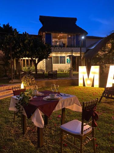 a table in the yard of a house at night at Hotel Villas Mariposas in Atlixco