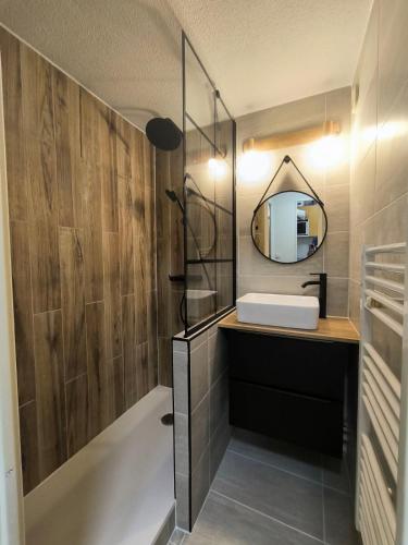 une salle de bain avec un lavabo et un miroir dans l'établissement VALFREJUS résidence chaviere, à Modane