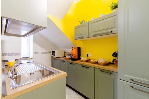 a kitchen with a sink and a yellow wall at Garçonnière Casa Caterina in Ischia