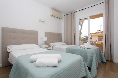 Una habitación de hotel con dos camas con toallas. en Albers Apartment, en Puerto de Alcudia