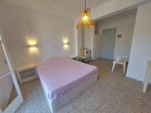 a bedroom with a bed and a chandelier at Koukos in Agia Theodoti