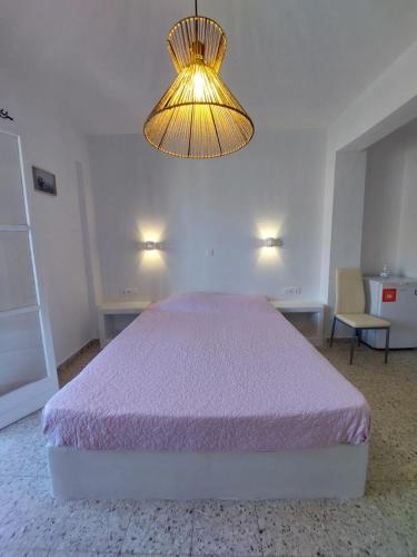 a bedroom with a bed and a chandelier at Koukos in Agia Theodoti