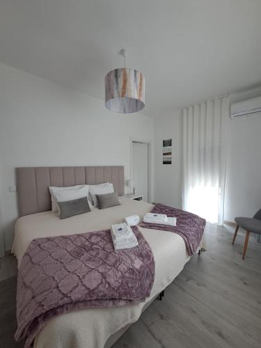 una camera da letto con un letto grande con due asciugamani sopra di ArouceHostel a Lousã