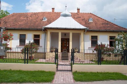 a white house with a gate and a roof at Bornemisza Kuria in Tiszabecs