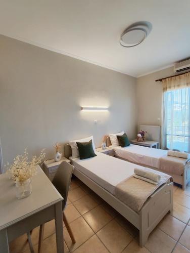 a living room with two beds and a table at Filoxenia Apartments in Mytilini