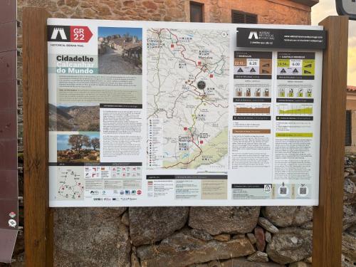 a sign with a map on a stone wall at Casa da Aldeia in Azevo