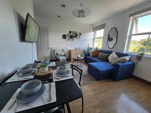 a living room with a blue couch and a table at Southampton City Centre Apartment Free Private Parking in Southampton
