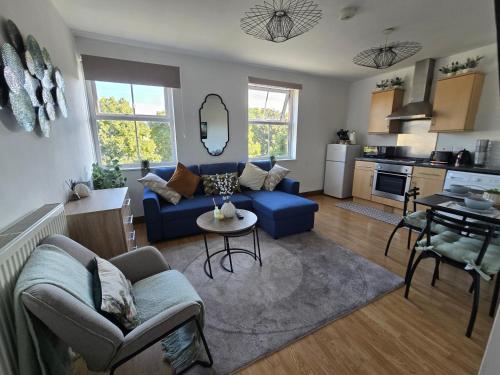 a living room with a blue couch and a kitchen at Southampton City Centre Apartment Free Private Parking in Southampton
