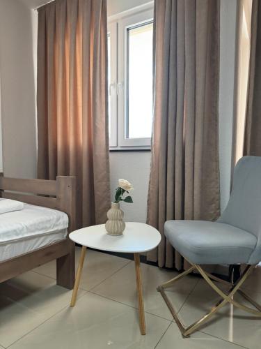 a bedroom with a bed and a chair and a table at Hotel Majestic in Struga