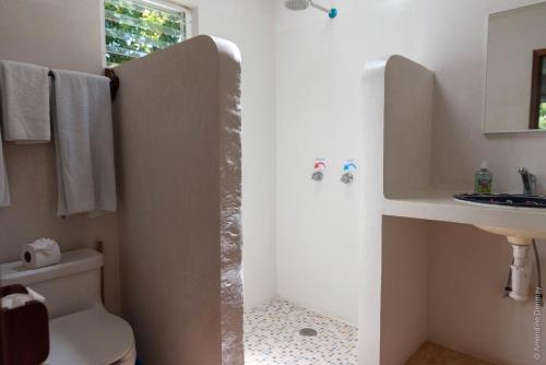 a bathroom with a toilet and a sink at Hotel & Suites Oasis Bacalar in Bacalar
