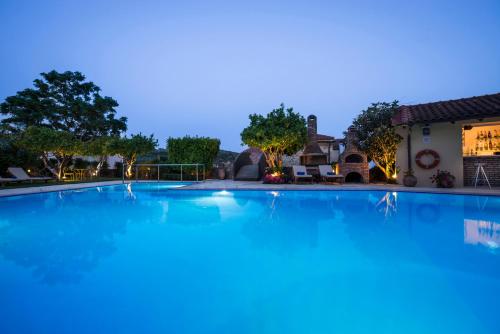 a large swimming pool in front of a house at Spilia Village Hotel & Villas in Spiliá
