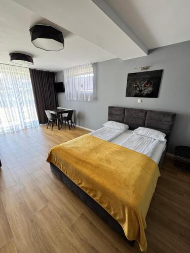 a bedroom with a large bed and a table at Trzy Małe Drzewka in Wielka Wieś