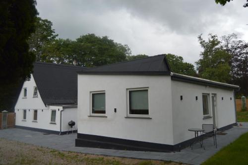 a white house with a black roof at Serengeti & Stayover in Svebølle