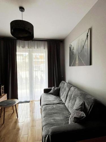 a living room with a couch and a large window at Apartament Słoneczna Dolina SPA Belle View in Szklarska Poręba
