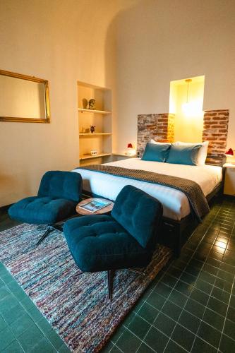 a bedroom with a large bed and two chairs at Casa Victoria in Spigno Monferrato