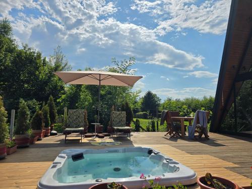 a hot tub with an umbrella on a patio at Api Aframe in Avrig