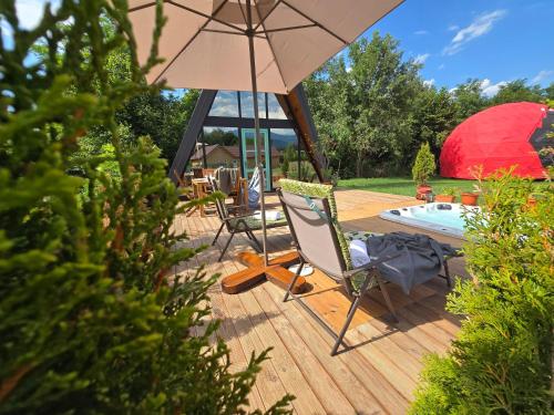 a patio with a chair and an umbrella at Api Aframe in Avrig