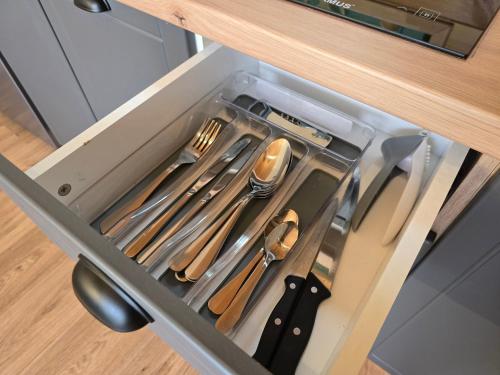 a drawer in a cabinet with utensils in it at Api Aframe in Avrig