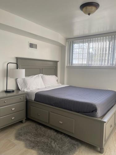 a bedroom with a bed with a blue comforter and a window at Entire 5 Bedrooms Home near DC and Metro in Silver Spring