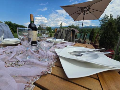 a table with glasses and a bottle of wine on it at Api Aframe in Avrig