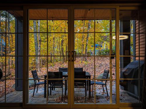 a dining room with a table and chairs through a window at luxurious Mont tremblant 2bd 2bth in Mont-Tremblant