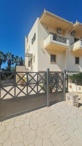 a white house with a gate and a fence at Aegina Horizon Stonehouse No I in Aegina