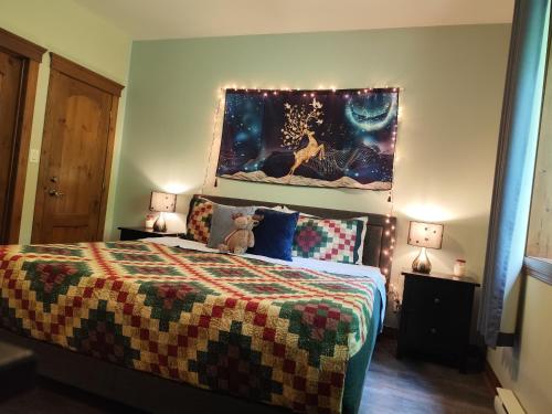 a bedroom with a bed and a painting on the wall at luxurious Mont tremblant 2bd 2bth in Mont-Tremblant