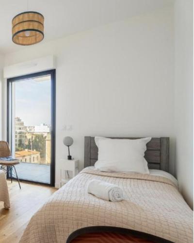 une chambre avec un grand lit avec une grande fenêtre dans l'établissement Saint Victor, double terrasse vue sur le vieux port, à Marseille