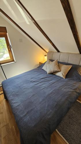 a bedroom with a large blue bed in a attic at Sunčev breg in Tuheljske Toplice