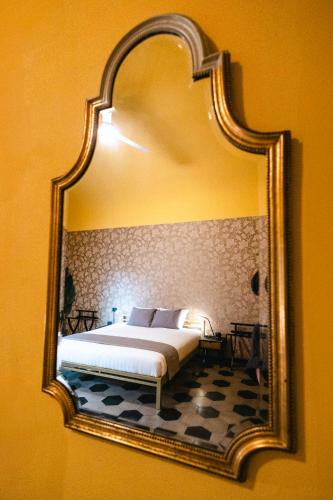 a bedroom with a bed and a mirror on the wall at Casa Victoria in Spigno Monferrato