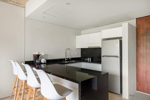 a kitchen with a black counter and white appliances at Sophisticated - Large Loft With Pool in Cancún
