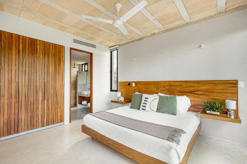 a bedroom with a large bed with a wooden headboard at Sophisticated - Large Loft With Pool in Cancún