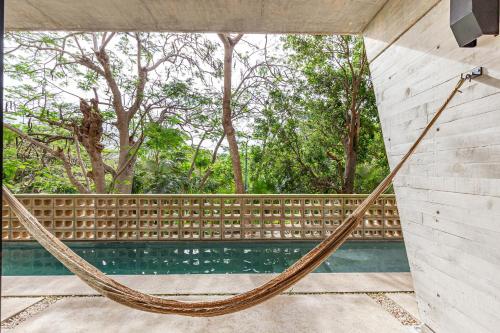 a hammock hanging from a wall next to a pool at Sophisticated - Large Loft With Pool in Cancún
