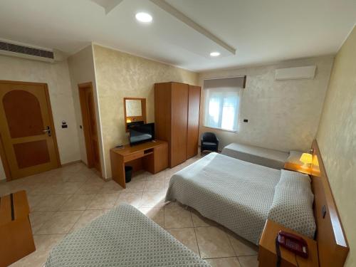 Ένα ή περισσότερα κρεβάτια σε δωμάτιο στο Hotel Toscano