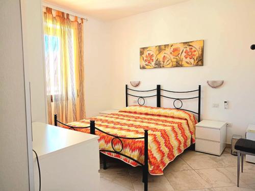 Un dormitorio con una cama y una mesa y una ventana. en Isola dei sogni, en Alghero